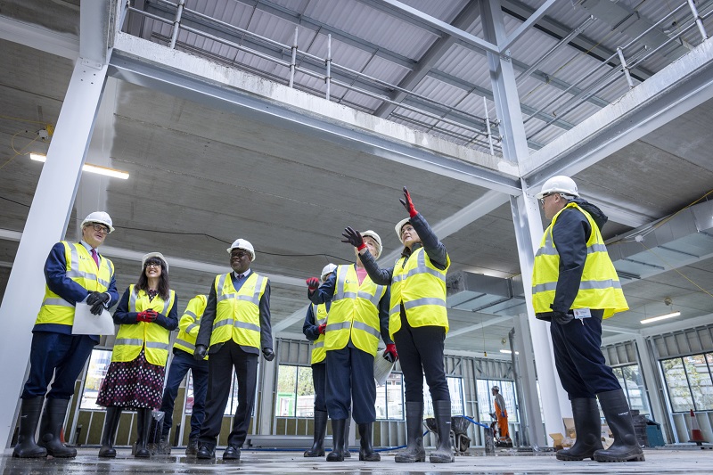 Stakeholders and construction leads tour the new building during a topping-out ceremony